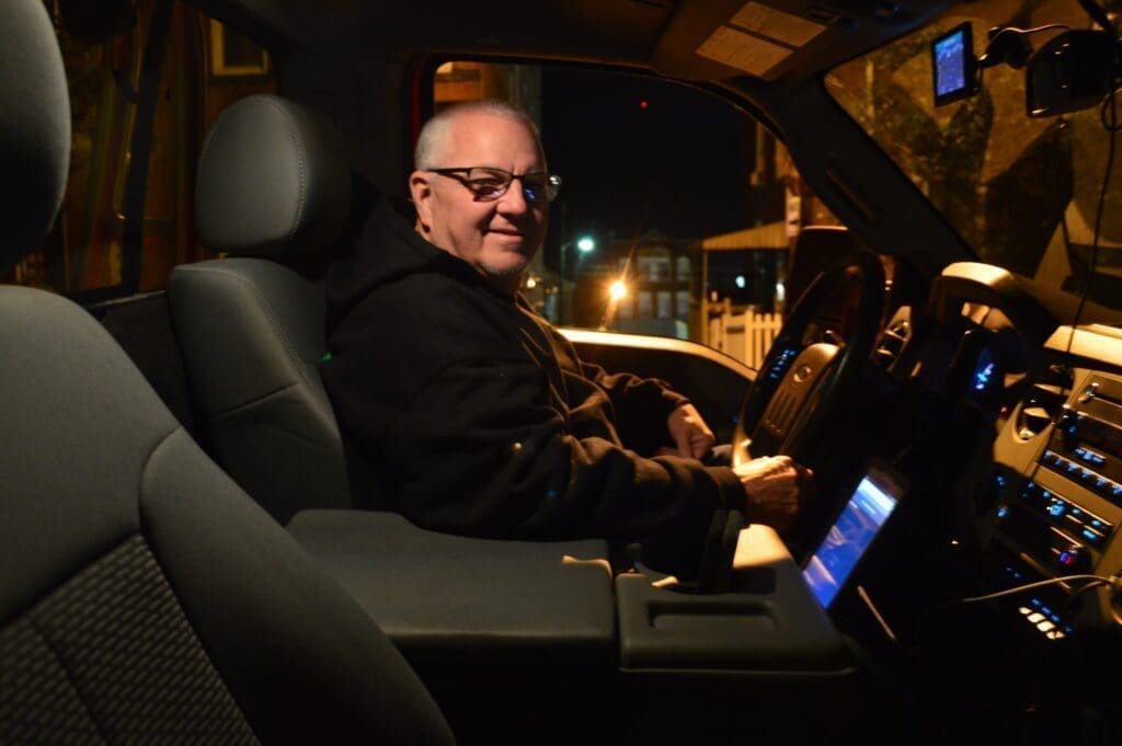 A tow truck driver sitting at the wheel.