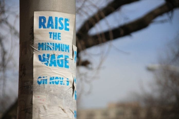 A worn sign demanding an increase in the federal minimum wage.