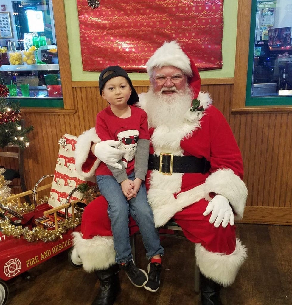 A photo of a child sitting on Santa's lap.