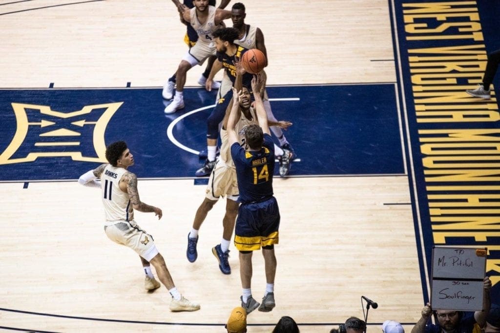 A photo of a basketball player shooting a jump shot from the right corner.