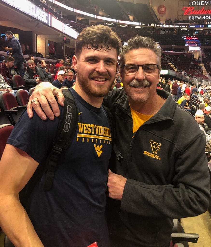 A photo of a father and son at a basketball game.