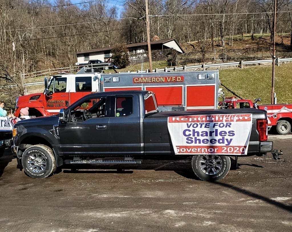 A photo of a pickup truck that is in a parade.
