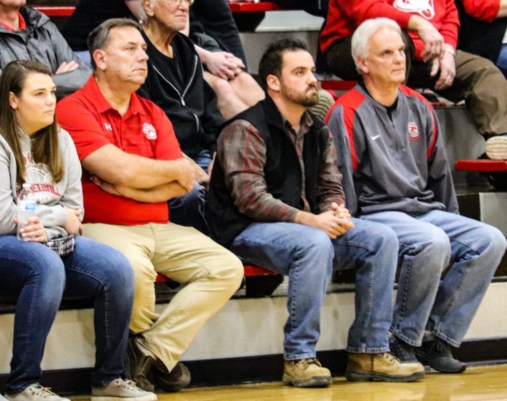 A photo of men sitting in the bleachers.