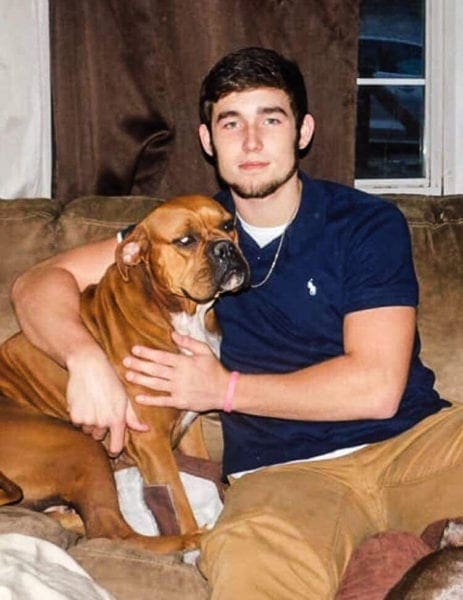 A young man and his boxer breed.