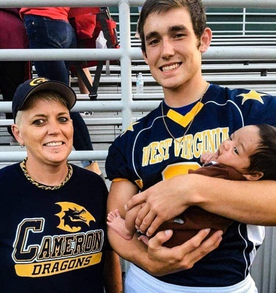 A mother, son, and grandson at a football game.