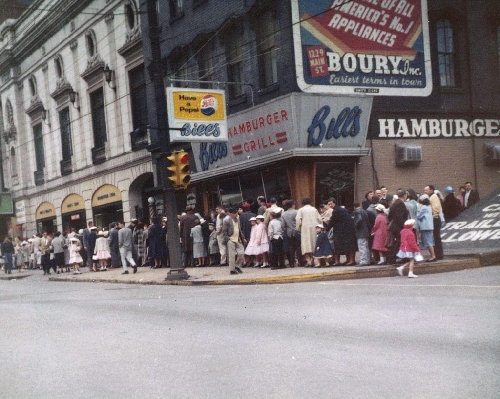 A long line waiting to get into a theatre.