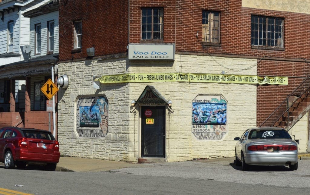 A long-time bar with cars outside.