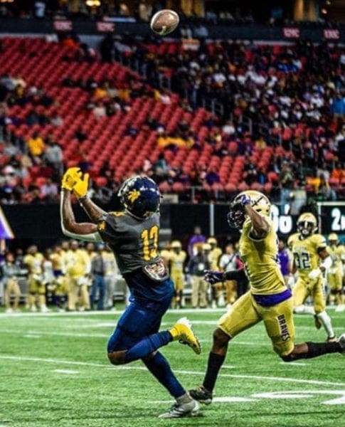 A football player about to catch a football.