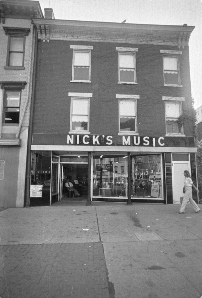 A person is walking passed a record store.