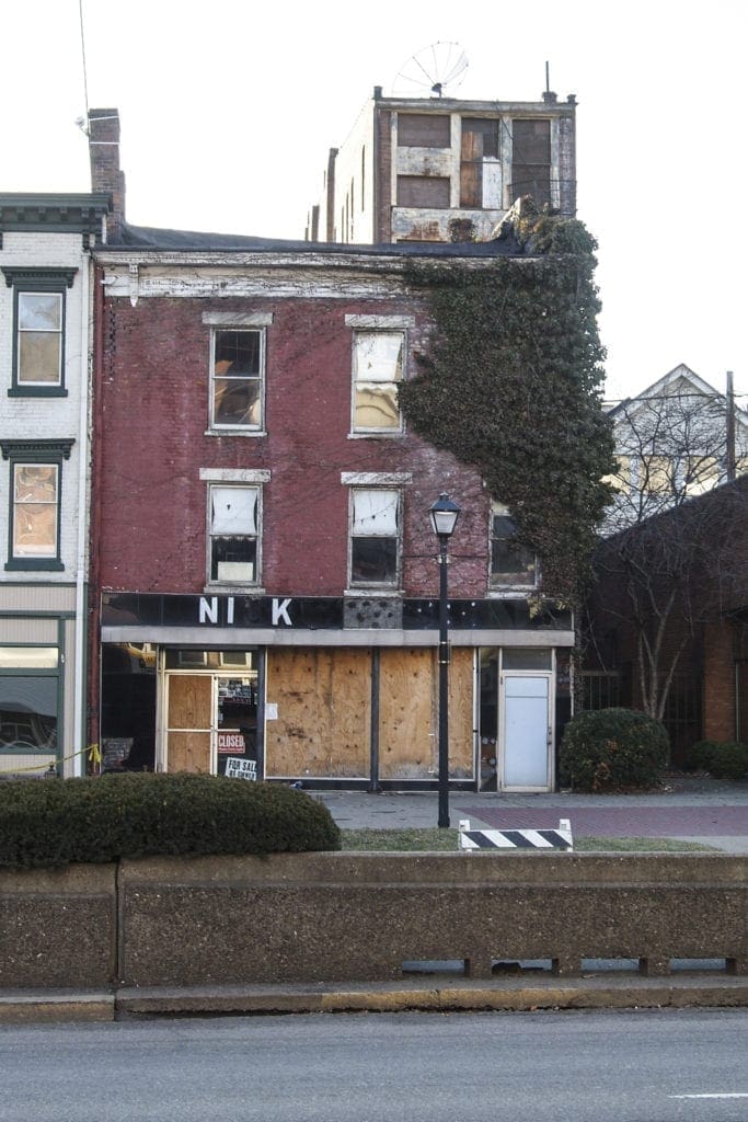 A photo of s boarded up building.