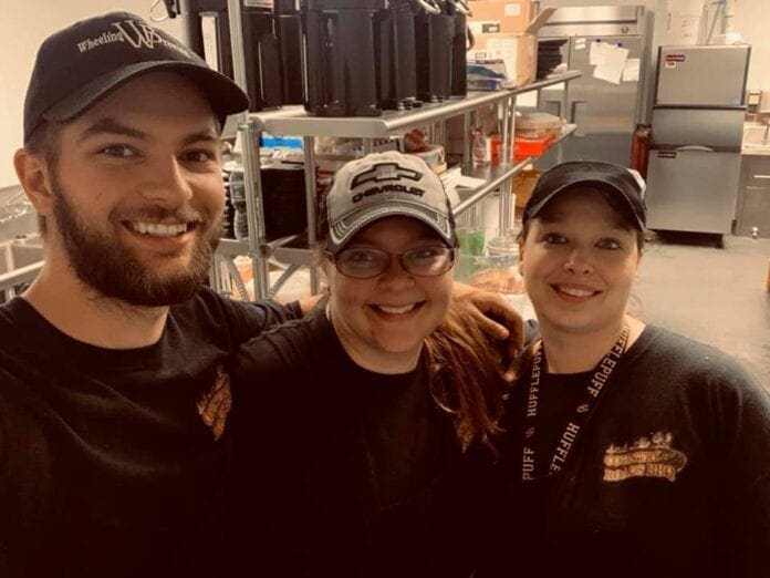 Kelly Phair, center, poses for a picture with her brother Kyle, left, and another employee of Country Roads.