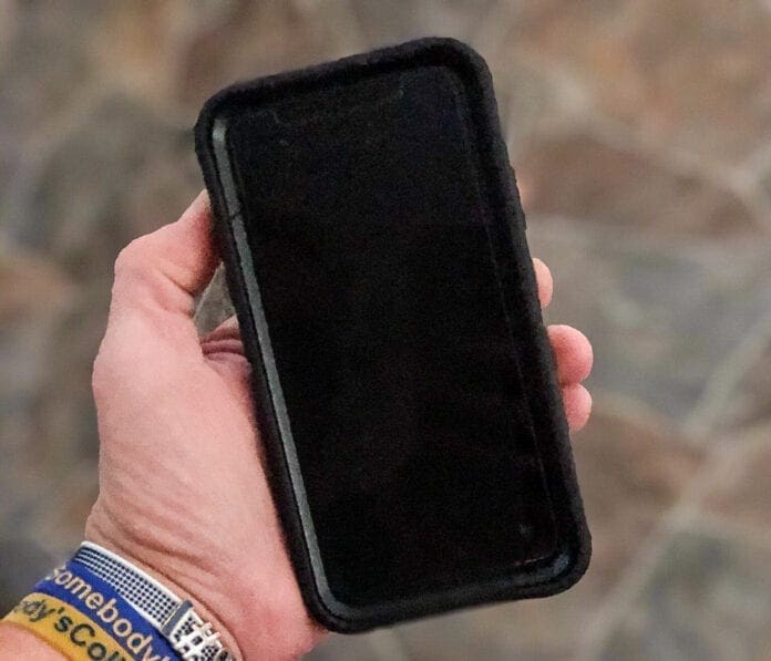 A photo of a person holding a smart phone.