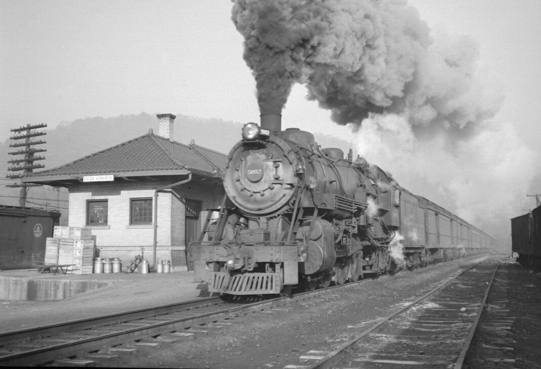 A historic photo of a train leaving the station.