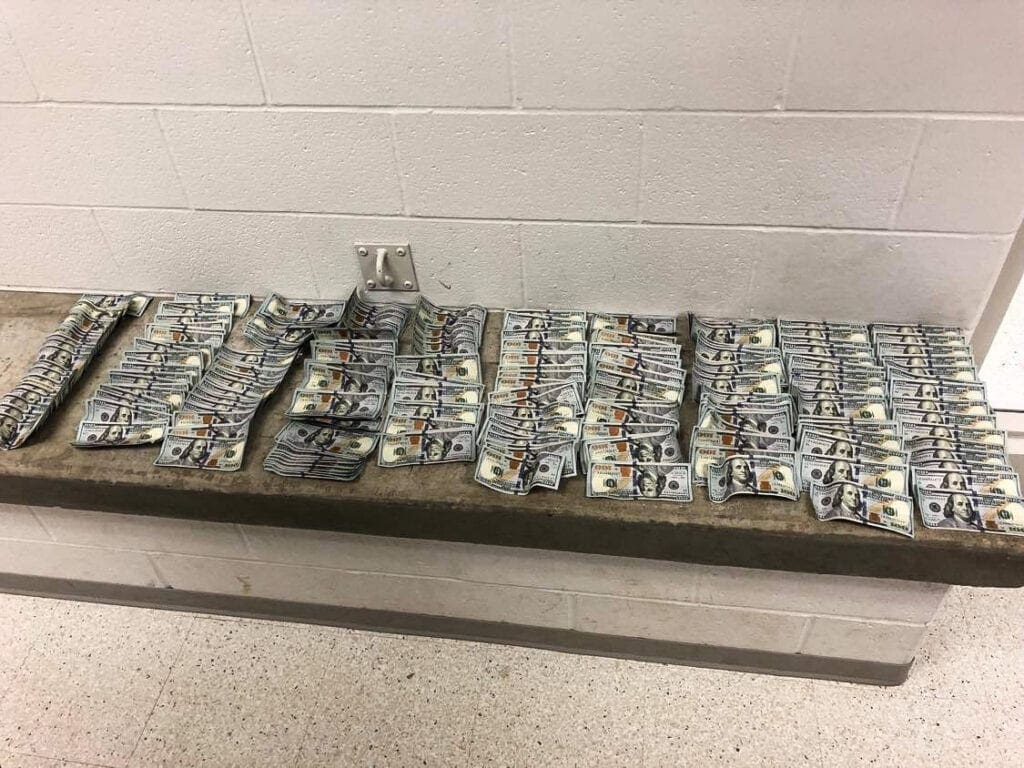 A concrete bench lined with cash.