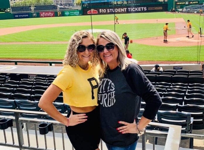 A mother and daughter at a baseball game.