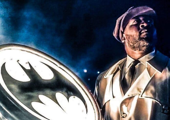 A man standing next to the Bat signal.