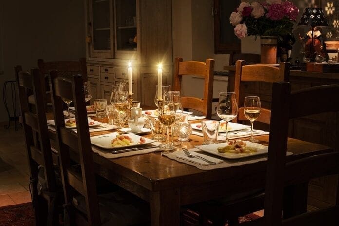 A phot of a dining room table with candle light.
