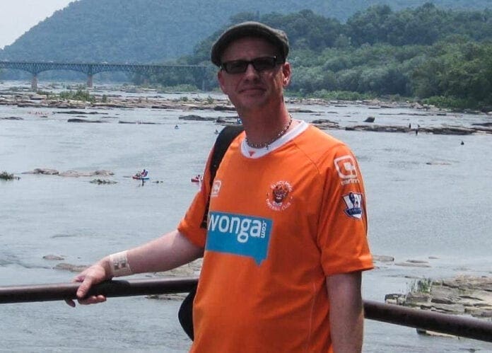 A man standing on a bridge over a river.