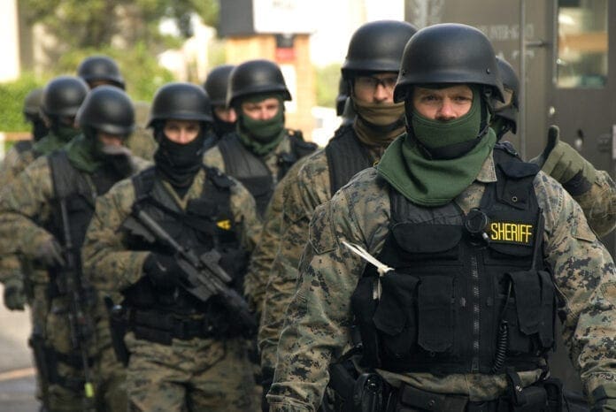 Police officers dressed in SWAT gear.