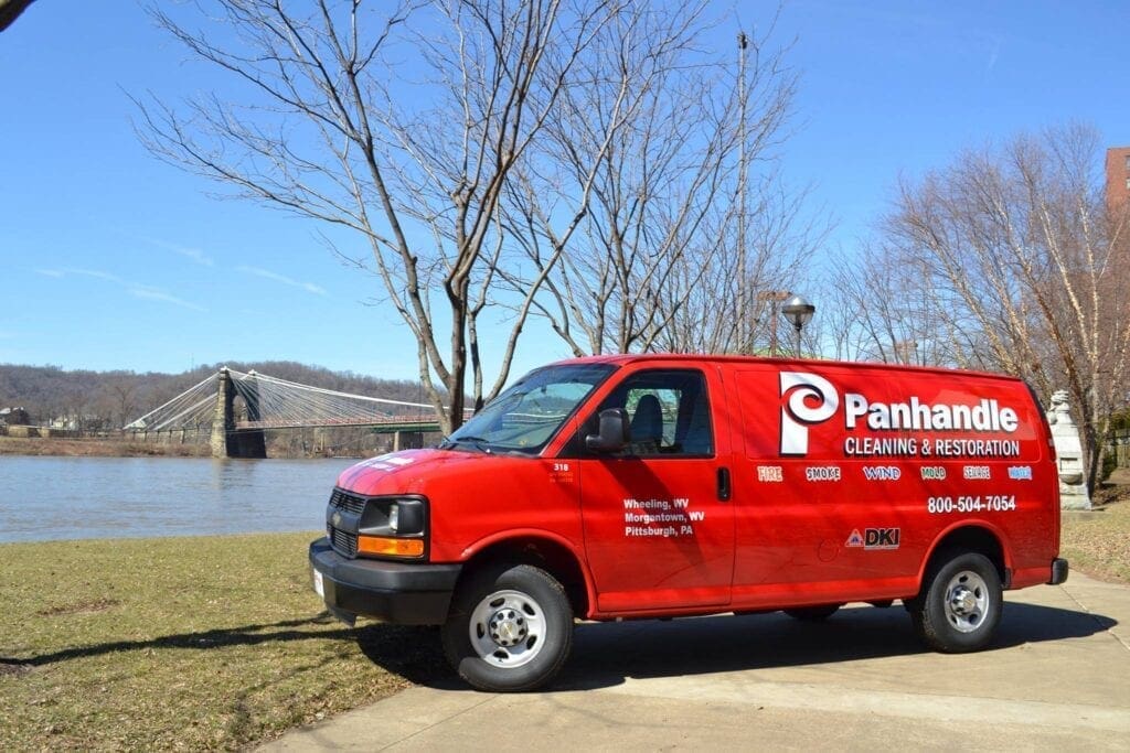 A red van on a riverfront.