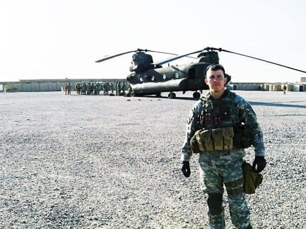 A man in front of a helicopter.