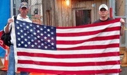 Two men holding an American Flag.