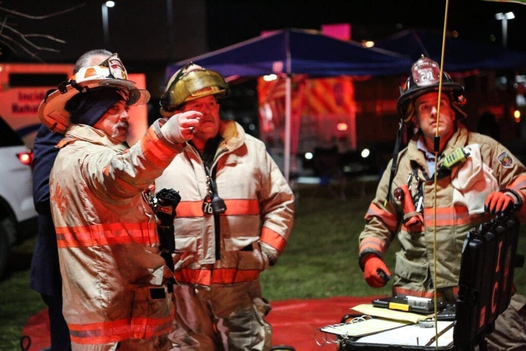 Firefighters look at a fire.