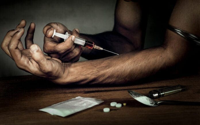 A man about to inject himself with drugs.