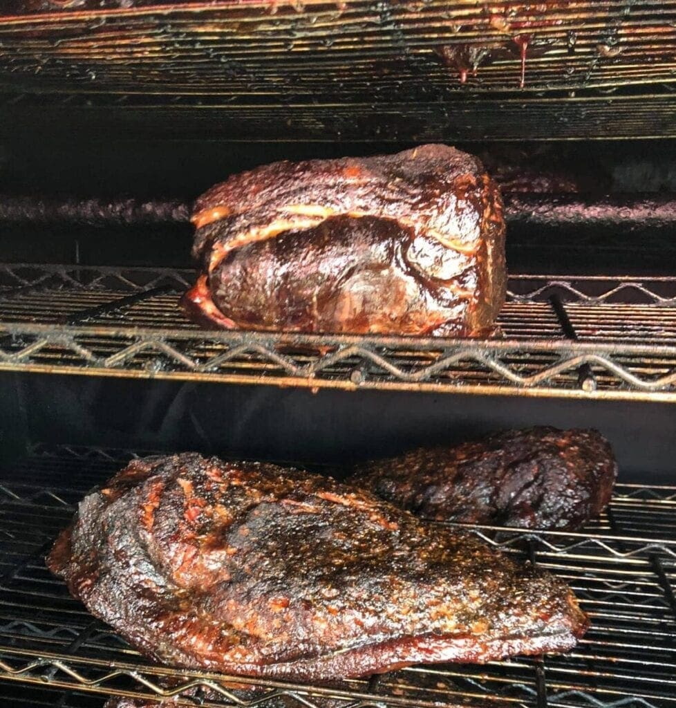 A pair of pork butts in a smoker.