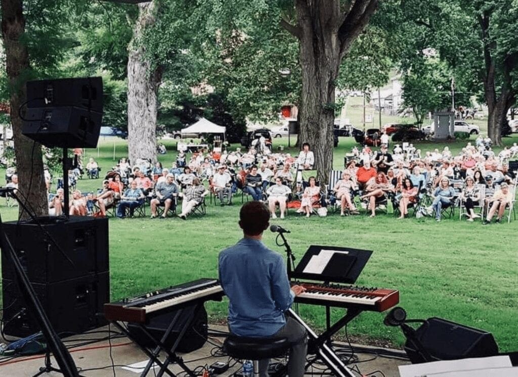 A man playing a keyboard at a performance.