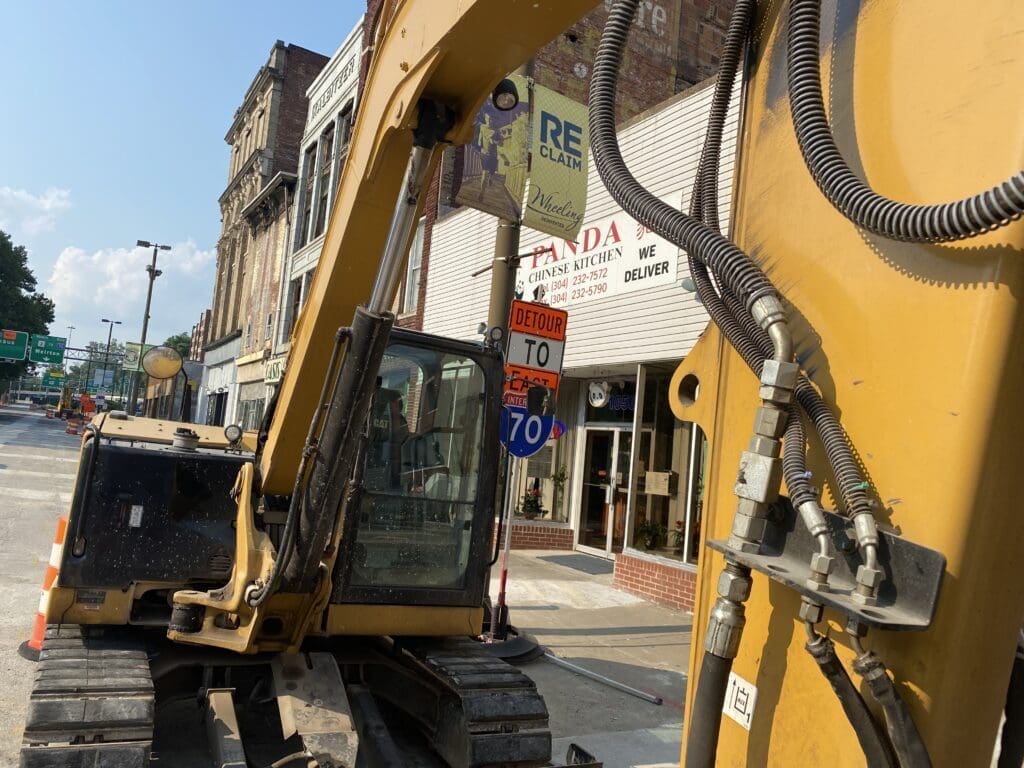 A large construction backhoe on a street.