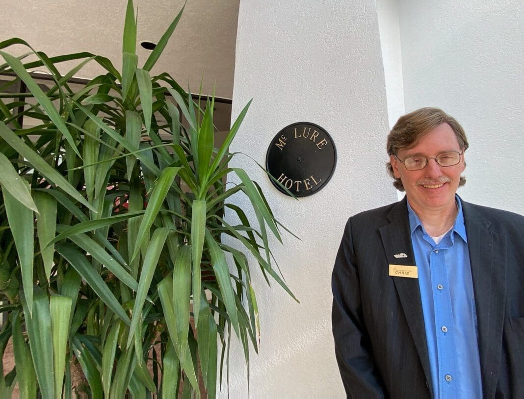 A man standing in front of a plant.