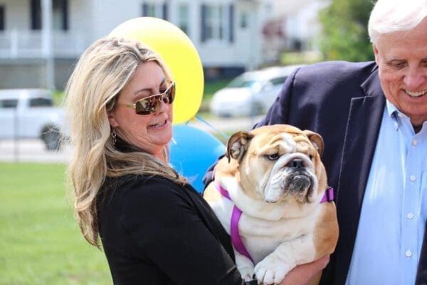 A woman holding a large dog.