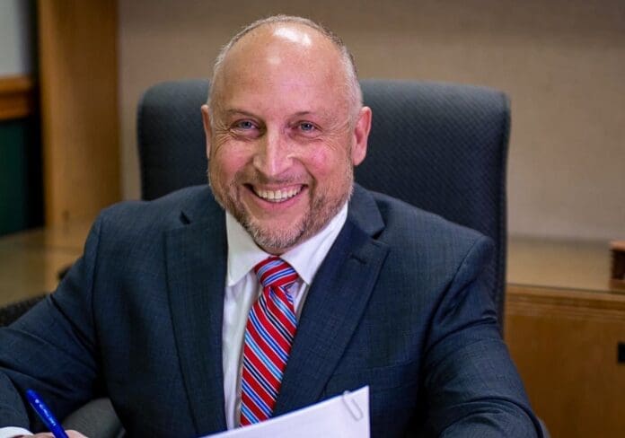 DAF57CA4-A348-42F0-86E8-41D09E61D1FE-min A man at a desk.