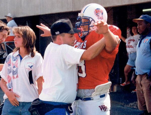 A man helping a football player.