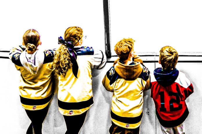 Kids watching hockey.