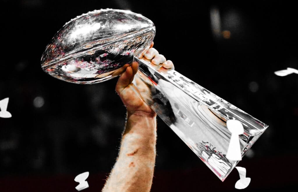 An arm hold the Lombardi Trophy.